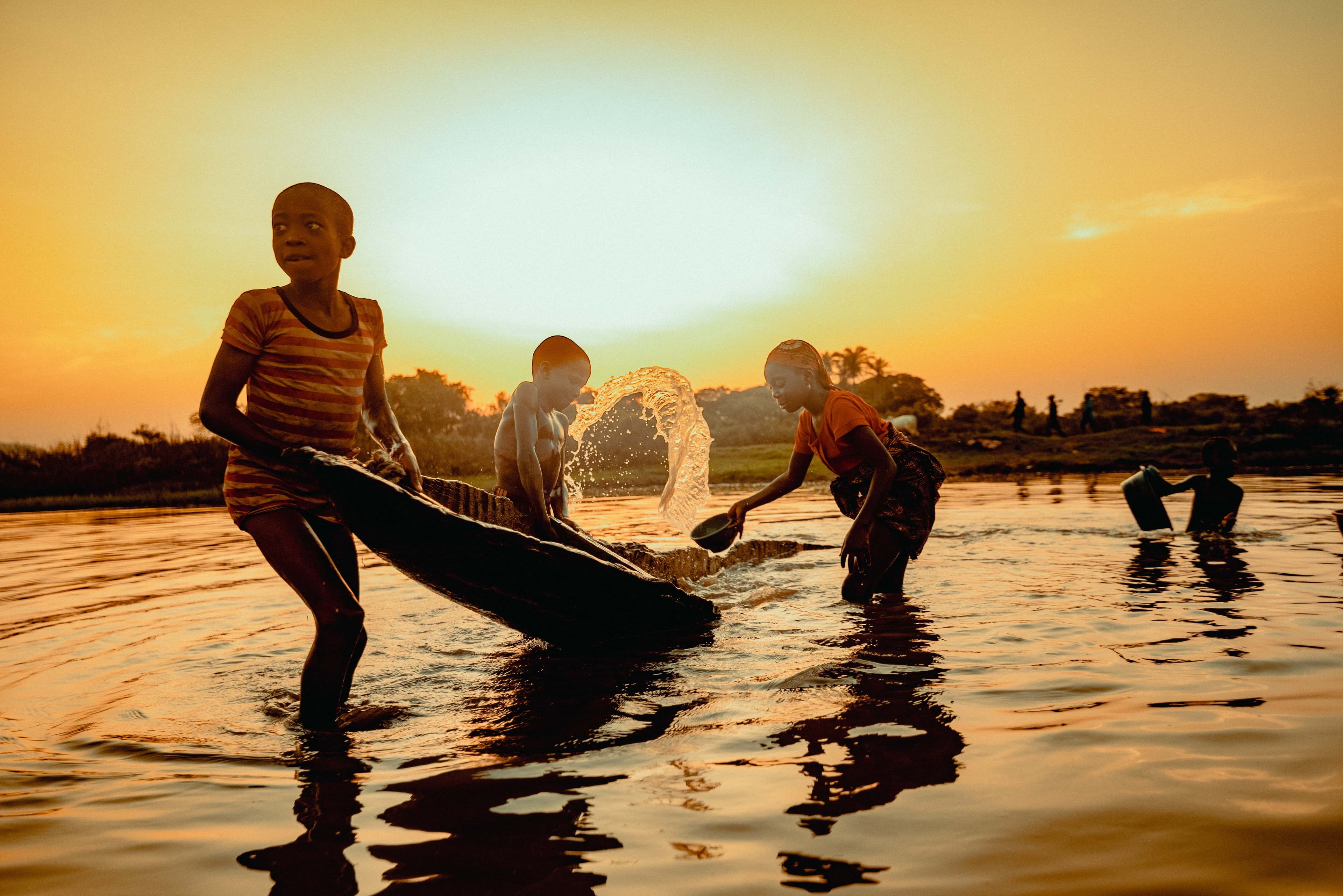 Two people in a traditional wooden canoe on Lake Victoria under open skies